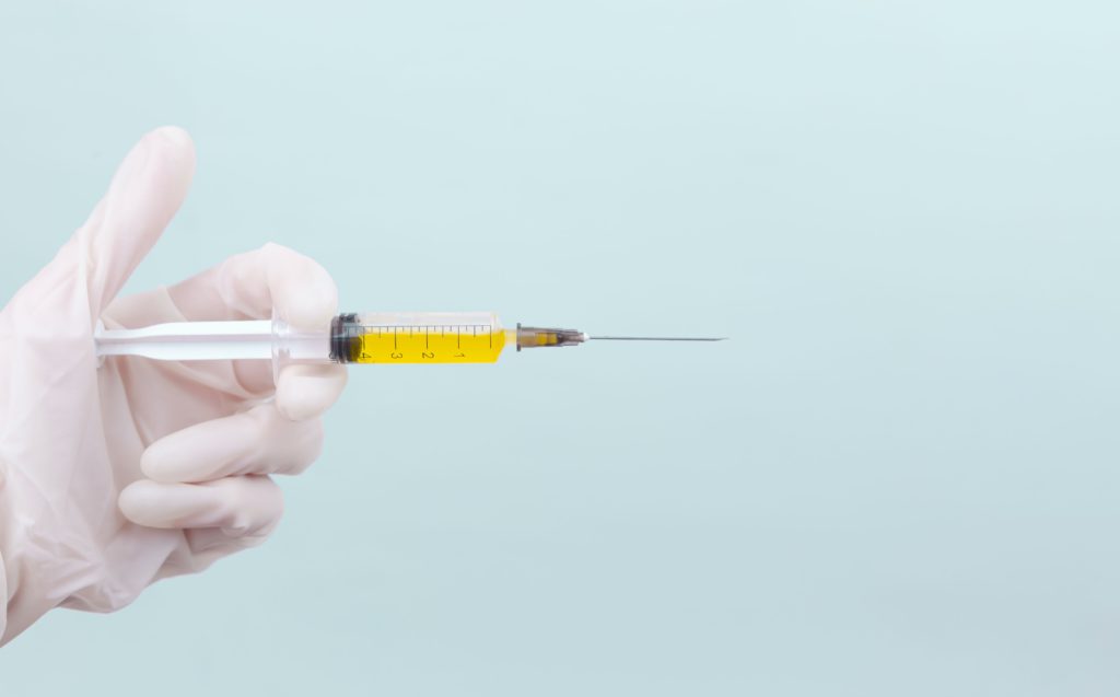 Report cover showing a medical syringe needle containing a vaccine